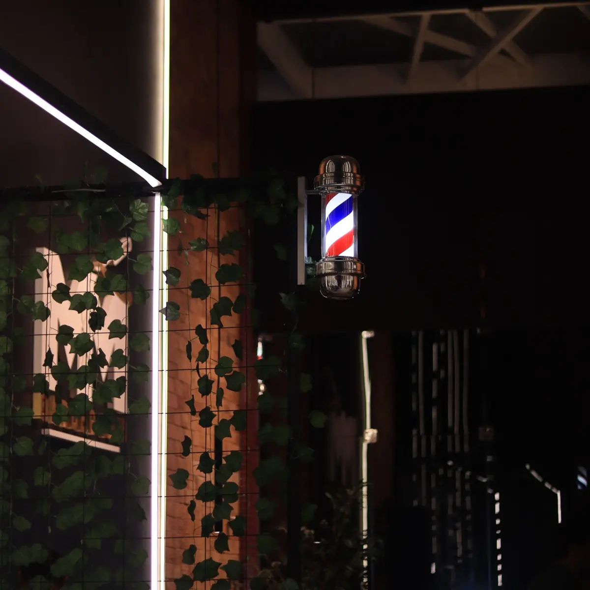 Entrada da barbearia com o barber pole aceso
