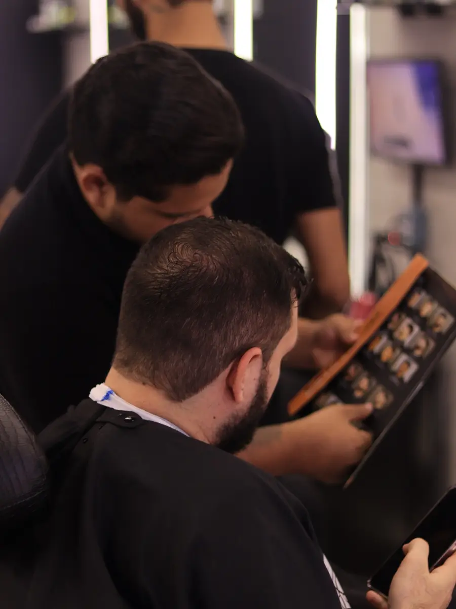 Cliente escolhendo o corte com o barbeiro